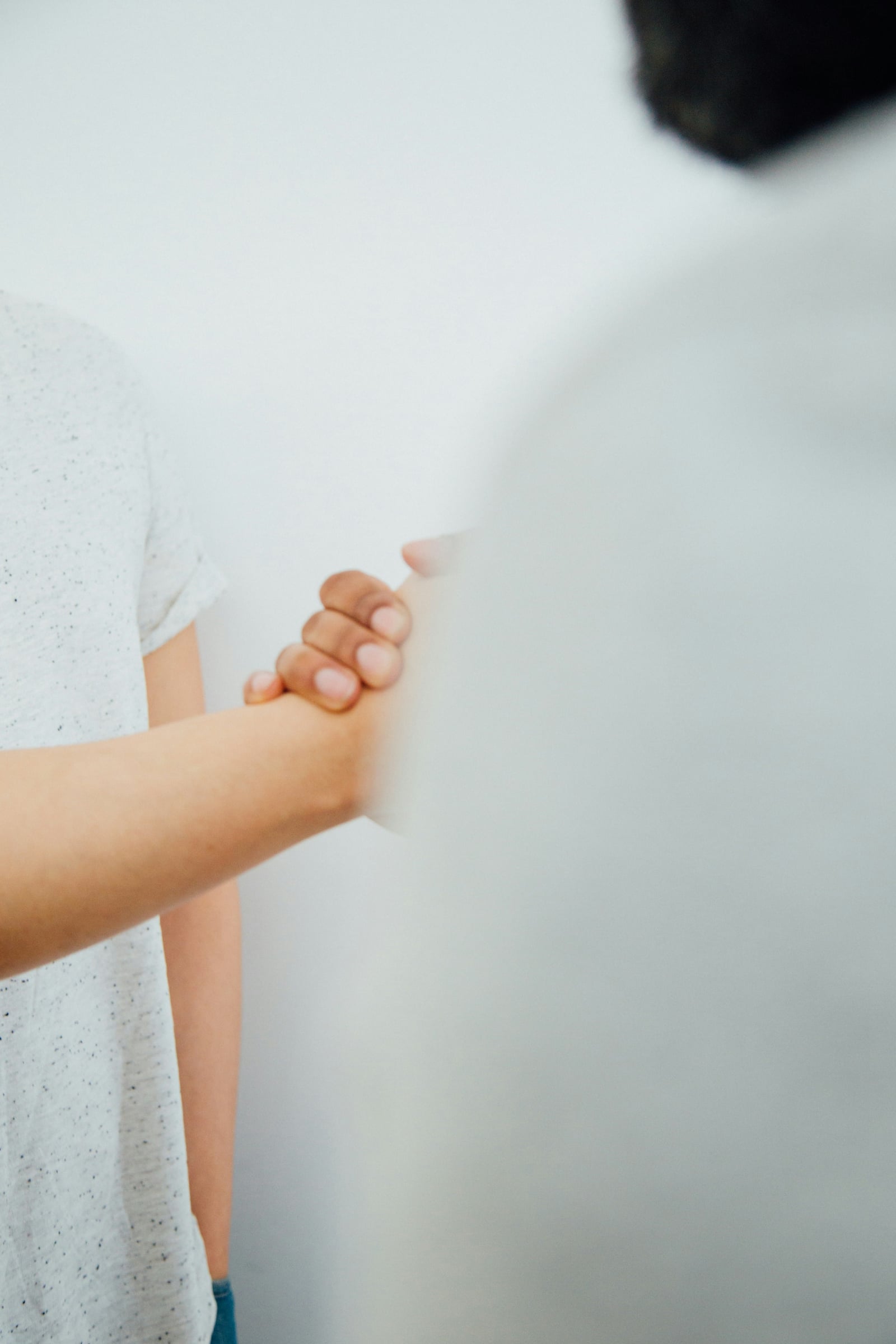 Two colleagues shaking hands, reflecting how health examinations help reduce sick leave at work